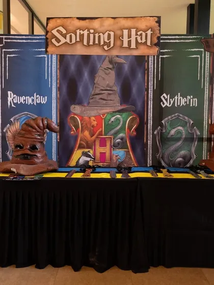 A full view of the Sorting Hat table, with multiple hats and house banners, ready for the ceremony to begin.