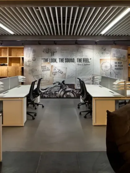 For the Harley-Davidson workspace, we translated the brand's iconic identity into a physical environment. This open-plan office features a custom mural with the tagline "The Look, The Sound, The Feel," surrounded by raw, industrial materials and displays of motorcycle parts, creating a space that authentically reflects the company's culture.