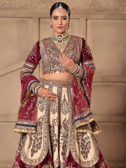A full portrait of the bride in her royal red and cream lehenga. The makeup is soft and warm, perfect for a day wedding.