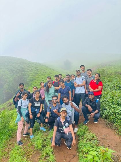 A large group photo on a narrow trail, everyone fitting in for the picture.