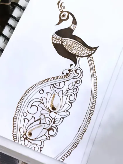 A practice sketch of a peacock with its tail forming a large paisley shape, filled with lotus flowers. This is a great way to combine multiple traditional elements.