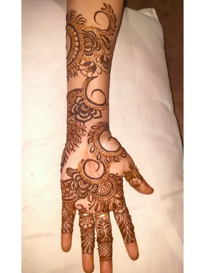 A bold, swirling paisley and floral design that covers the hand and extends up the arm. This is a classic and elegant choice.