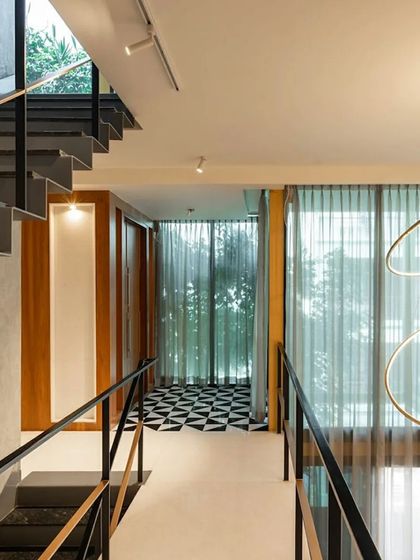 The bridge on an upper level of 'SOL' connects two private zones. The design uses a bold checkered floor pattern as a visual accent, demonstrating how we introduce surprising details to animate circulation spaces.