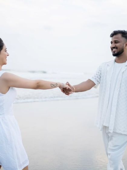 A playful "follow me to" style shot on the beach, capturing the fun and connection of the couple.