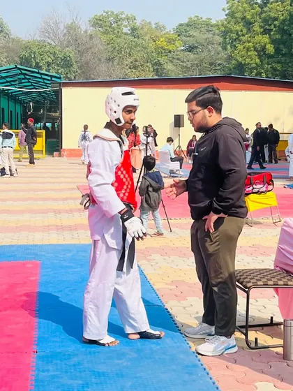 Strategic advice is just as important as physical training. This photo captures a key coaching moment with Ansh Sharma during the Delhi Olympic Games.