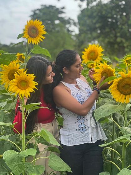 Two friends in a field of sunflowers in Wayanad.
