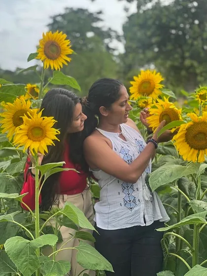 Two friends in a field of sunflowers in Wayanad.