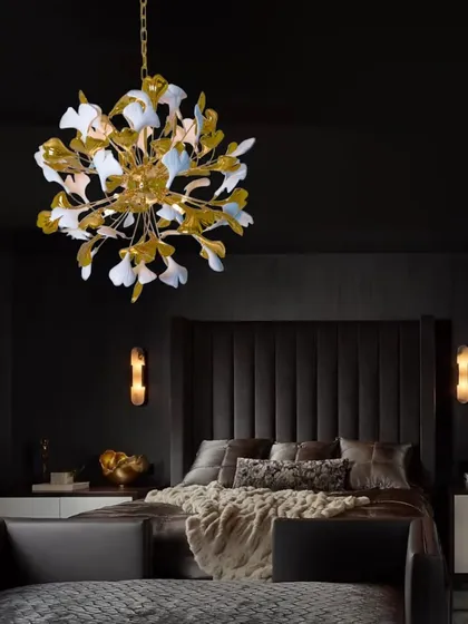A beautiful floral chandelier installed above a bed, creating a luxurious and artistic focal point in a dark, moody bedroom.