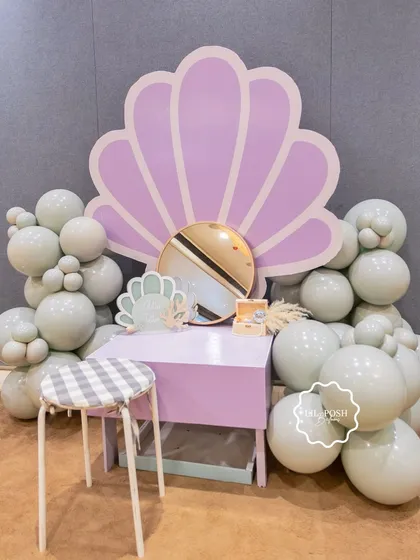 A vanity station for the glitter tattoo artist, set against a large seashell backdrop.