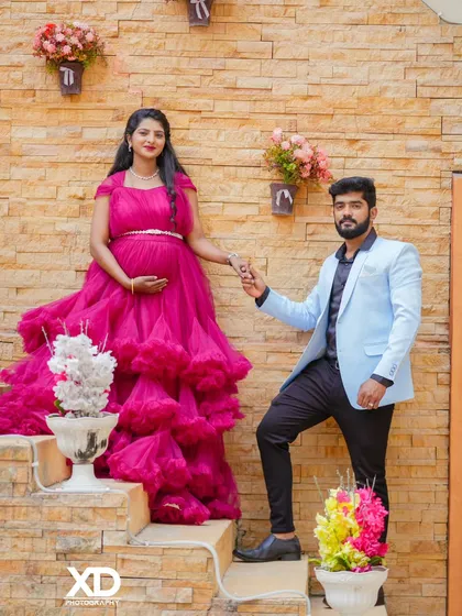 A stylish couple's portrait on a rustic staircase, with the partner leading the mother-to-be.