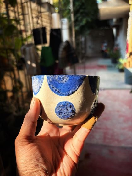 A small wheel-thrown bowl with a textured blue polka dot pattern. This was one of Shreya's early pieces where she was experimenting with surface decoration.