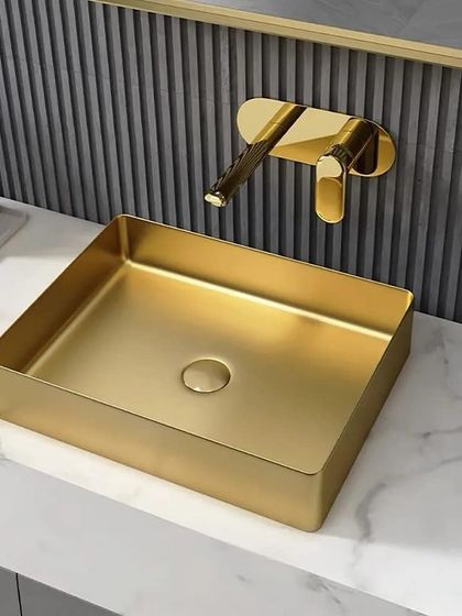 This rectangular vessel sink in brushed gold adds a touch of modern luxury. It's paired with a wall-mounted faucet, which keeps the countertop clear and easy to clean. The fluted wall panel behind adds texture and depth.