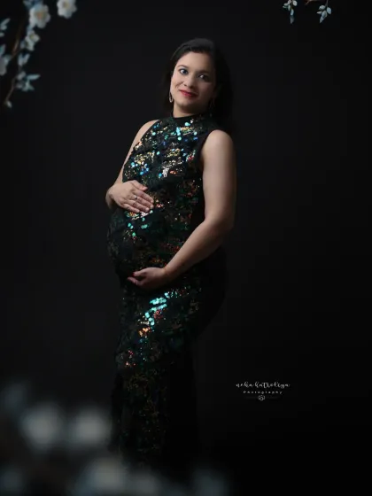 A forward-facing portrait in the green sequin gown, showcasing how it beautifully accentuates the baby bump with a touch of sparkle.