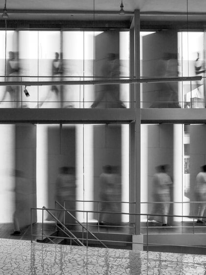 A long-exposure photograph captures the sense of movement within the Artrovert studio. The design features swiveling panels that can display artwork to either the interior or the public, blurring the lines between gallery and workspace.