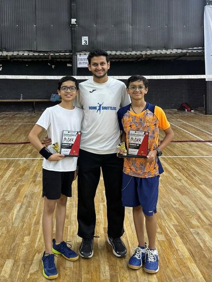 Our boys' under-15 doubles runners-up, Manav and Arnav, with their coach. We place a strong emphasis on teamwork and strategy in our doubles training programs.