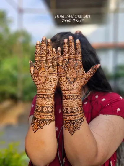 A full view of the engagement mehendi, showing the detailed patterns on the palms and the floral cuff design on the wrists.