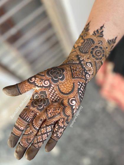 A single hand view of a semi-bridal design, showcasing the intricate floral and geometric work.