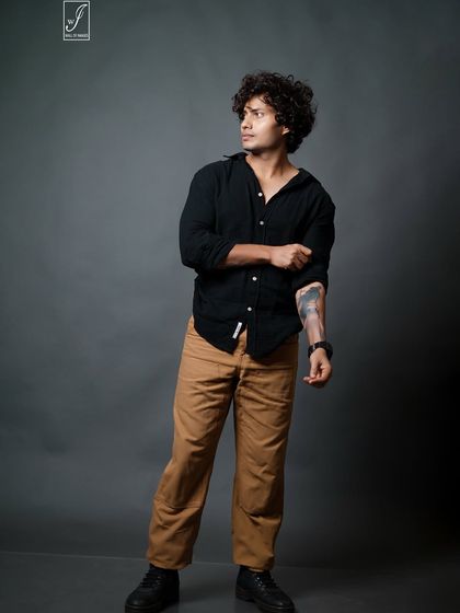 This shot highlights the model's arm tattoo and captures a candid, off-camera glance, adding personality to the series.