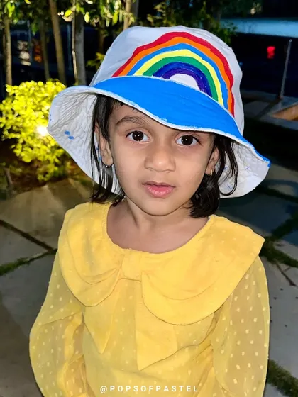 Another adorable artist showing off her hand-painted rainbow hat. Wearable art is always a hit.