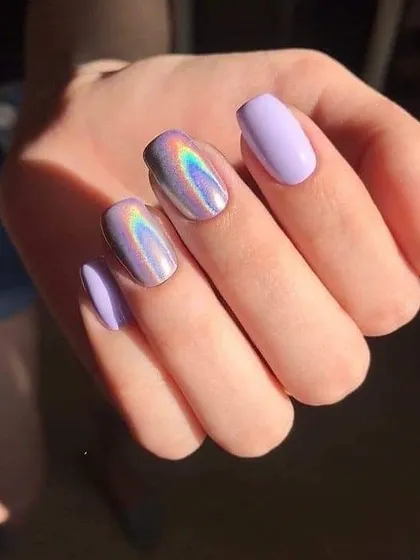 Can't get enough of holographic nails. This set combines solid lilac nails with accent nails that have a stunning holographic finish, creating a rainbow effect in the light.