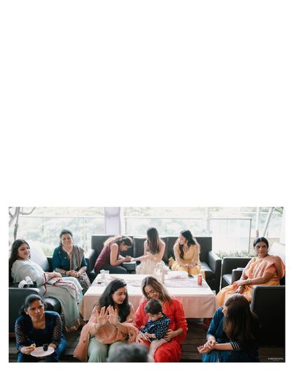 A wide shot of the Mehendi ceremony, showing women and children gathered together. It captures the communal and celebratory nature of this important pre-wedding ritual.