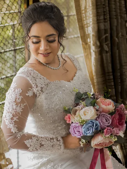 A beautiful portrait of the bride looking down at her bouquet. Her soft eye makeup and glowing skin are the highlights of this look.