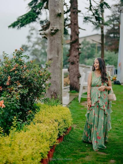 The bride enjoying a quiet moment in the garden. Her natural makeup look complements the serene, green surroundings.