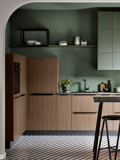 This modular kitchen blends urban design with natural warmth, using a palette of metallic green and natural walnut. The result is a space where modernity meets nature.