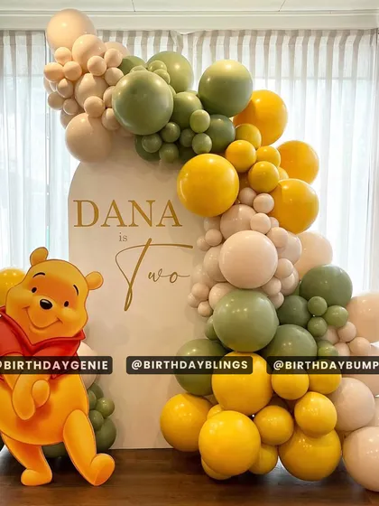 A sweet Winnie the Pooh theme for a second birthday. The design uses a muted color palette of sage green, yellow, and cream, with a life-sized Pooh cutout.