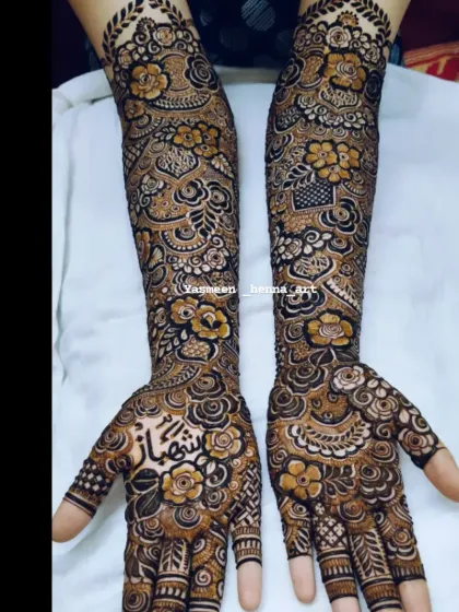 Hiba's mehndi, with the groom's name 'Shehbaz' beautifully written on her palm amidst a garden of henna flowers.