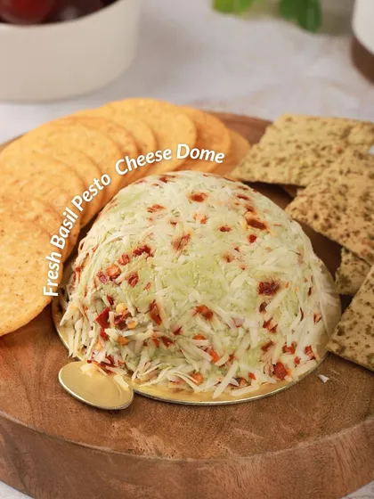 Our Fresh Basil Pesto Cheese Dome is a vibrant and aromatic choice. The creamy cheese is infused with homemade pesto and coated with parmesan and chili flakes for a zesty finish.