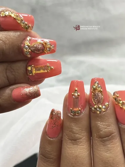 This side view highlights the dimension of the gold charms and crystals, showing how they are securely sculpted onto the nail.