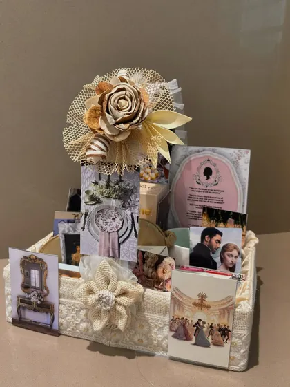 We bring your favorite themes to life, like this elegant Bridgerton-inspired hamper. It's filled with curated items that capture the regency era vibe, all arranged in a beautiful lace-covered basket.