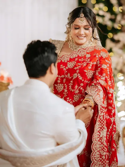 A romantic moment as the groom puts a ring on the bride's finger.