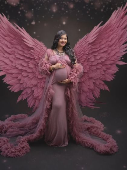 A divine moment in time, where art meets motherhood. This ethereal shot with pink angel wings embodies grace and strength.