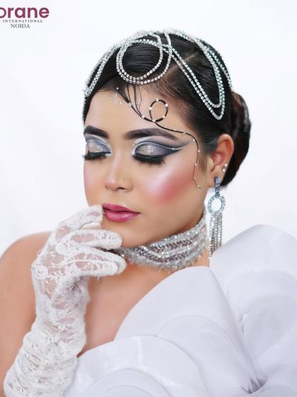 The closed-eye pose allows for a full appreciation of the dramatic, layered eyeliner and shimmering highlight.