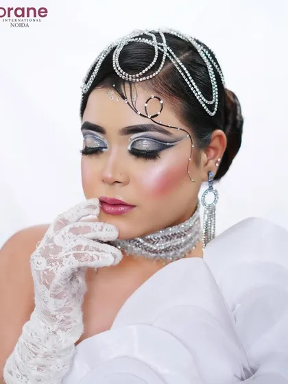 The closed-eye pose allows for a full appreciation of the dramatic, layered eyeliner and shimmering highlight.