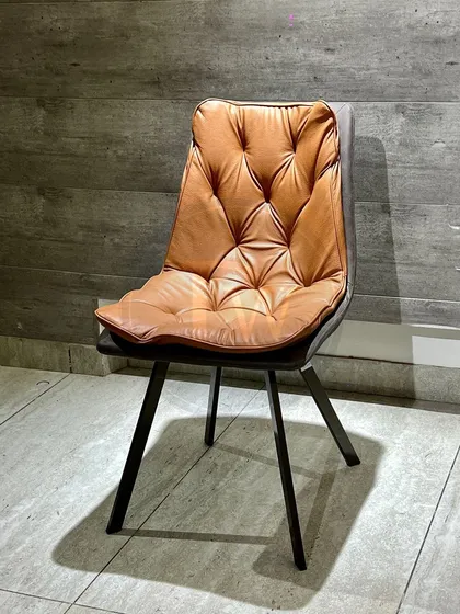 For those who love a more industrial or rustic look, this chair with a tufted tan leatherette seat and sleek metal legs offers both style and easy maintenance.