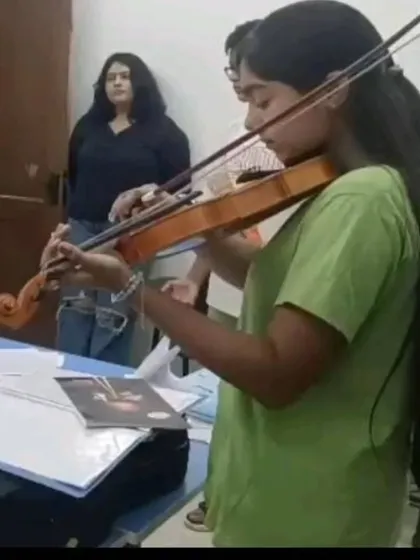 A violin student receives guidance from her instructor during a practice session. Our teachers work closely with students to help them perfect their posture, bowing technique, and intonation.