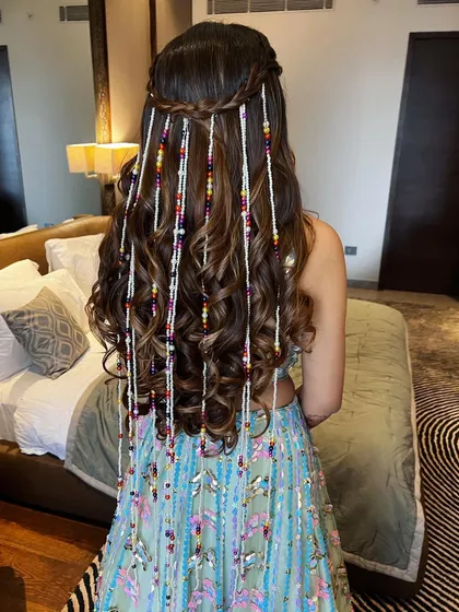 A close-up of the half-up hairstyle with beaded strands, highlighting the intricate details. This is a great way to incorporate your outfit's colors into your hair.