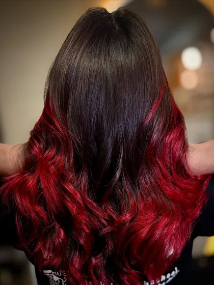 A perfect example of a bold red ombré on dark hair. I achieve this dramatic, fiery look by carefully blending the vibrant red into the natural base, creating a seamless fade that’s full of life and styled into beautiful, flowing waves.