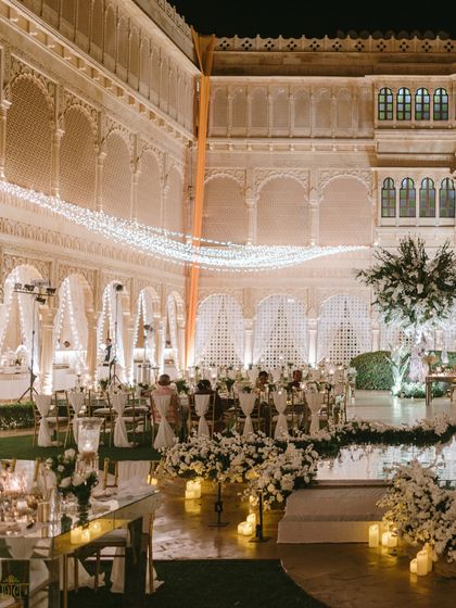 The all-white reception at night, with strings of fairy lights creating a magical canopy over the courtyard. The design focused on creating a dreamy, ethereal atmosphere that felt both grand and incredibly romantic.