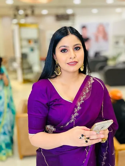 This client looks confident and poised. The rich purple of her saree is complemented by a soft, smoky eye and a neutral lip.