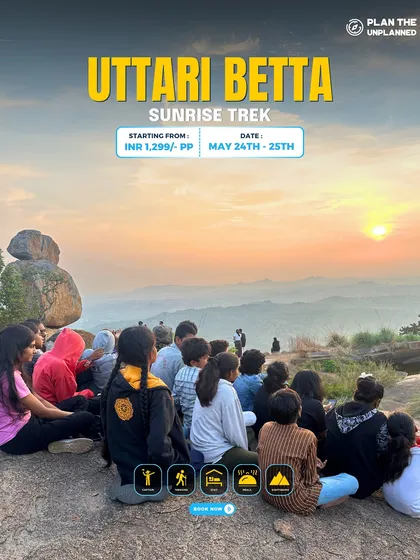 A group watches the sunrise from the top of Uttari Betta.