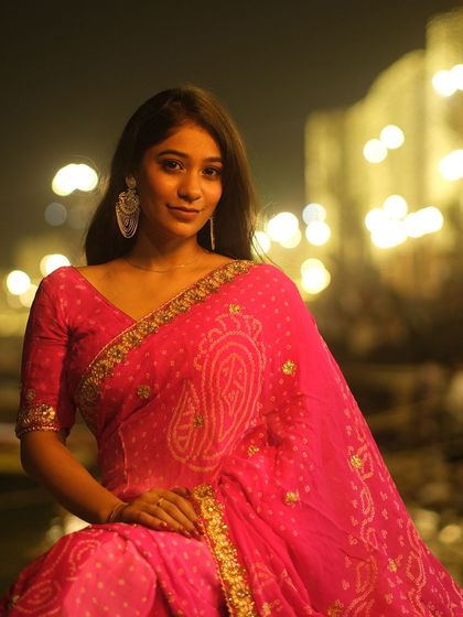 A beautiful portrait on the ghats at night, with the shimmering lights on the Ganga creating a magical bokeh effect.