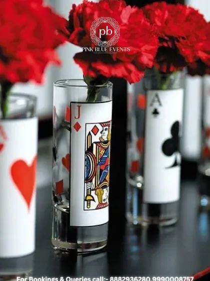 It's all in the details. For a Diwali card party, we use creative centerpieces like these vases decorated with playing cards and filled with beautiful red carnations.