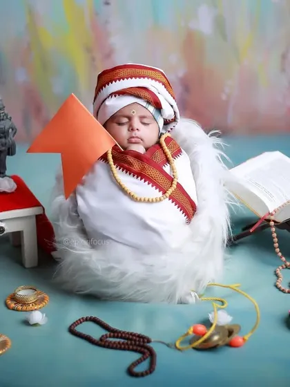 The 'Little Vitthal' setup, showing the baby sleeping peacefully amidst the carefully arranged props, including miniature idols and a holy book.