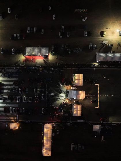 Another perspective of the vibrant night festival. The lights, the crowd, and the sound of distant engines create an unforgettable atmosphere.