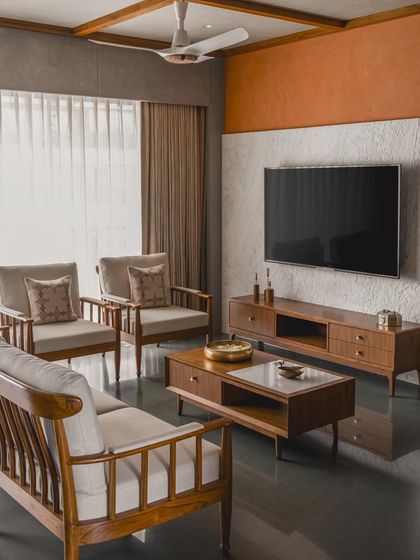 This apartment in Surat blends Indian heritage with modern minimalism, featuring teak wood furniture, lime-washed walls, and a warm, earthy color palette.