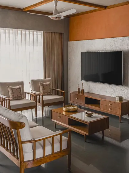 This apartment in Surat blends Indian heritage with modern minimalism, featuring teak wood furniture, lime-washed walls, and a warm, earthy color palette.